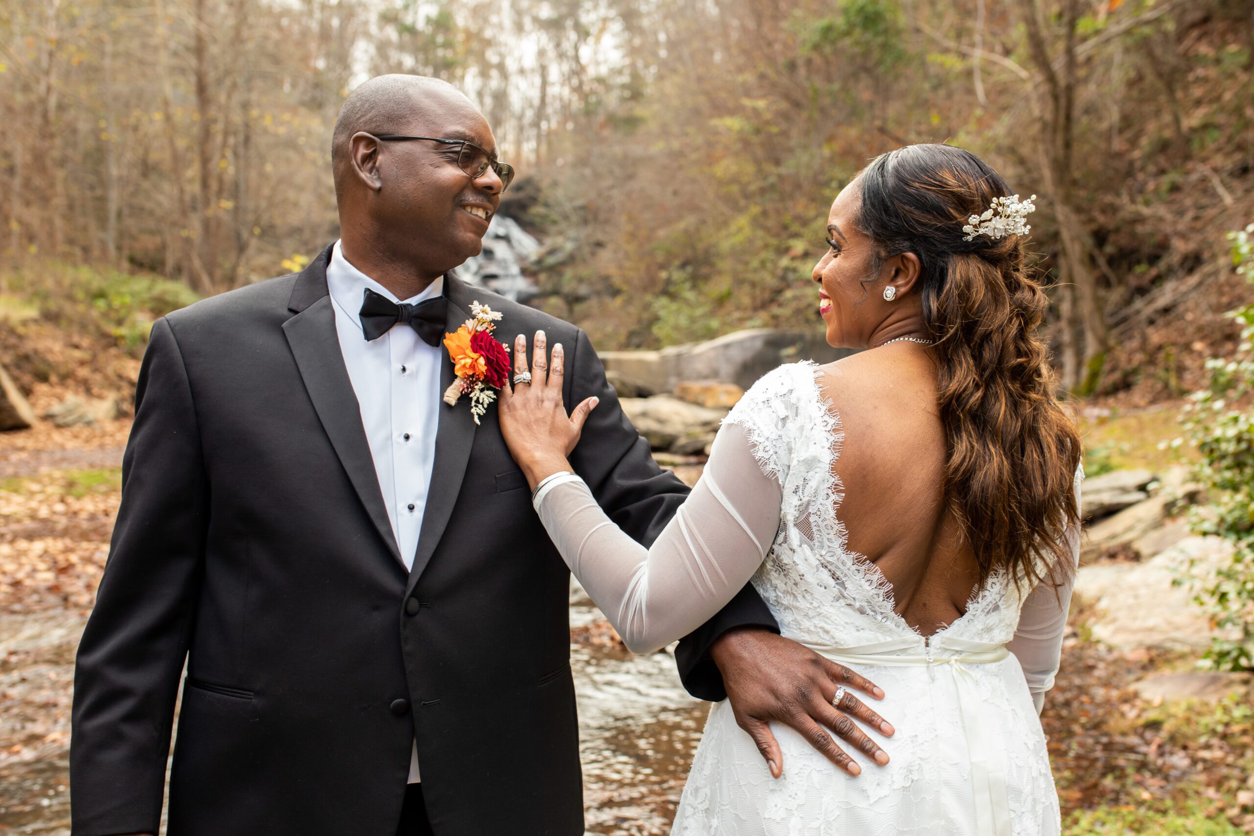 North Georgia wedding venue bride and groom pose for photos at a luxury outdoor wedding ceremony bridge with waterfall