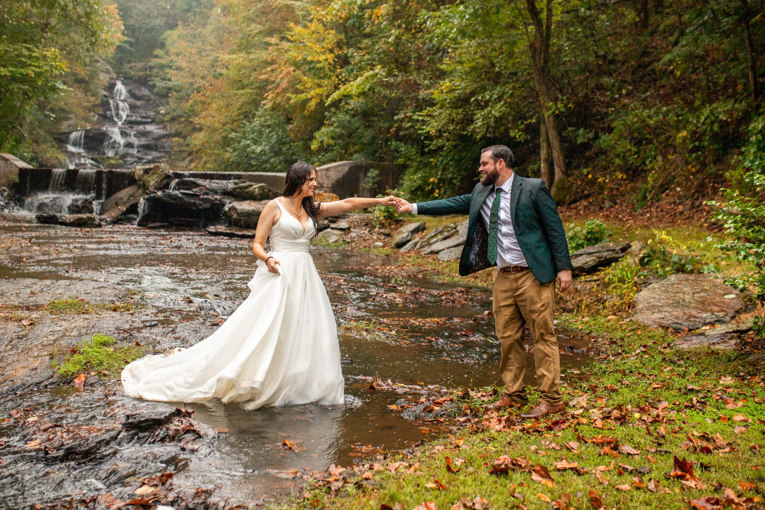 North Georgia wedding venue bride and groom pose for photos at a luxury outdoor wedding ceremony bridge with waterfall