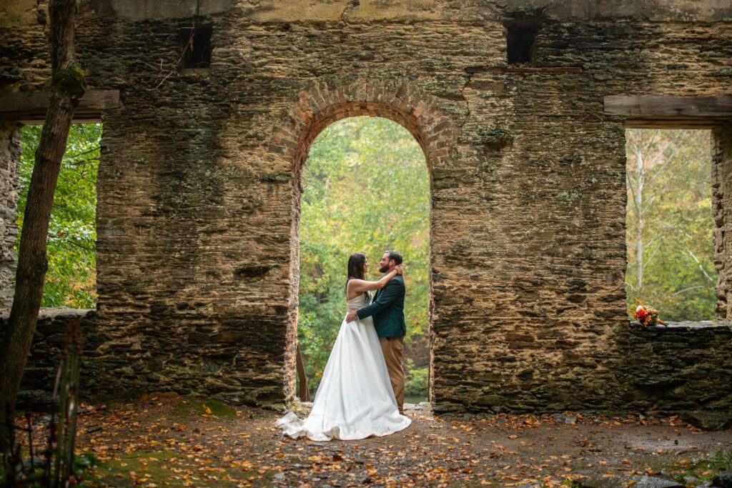 Best All-Inclusive Wedding Venue in Georgia, Historic ruins by a wedding waterfall, bride in luxury designer wedding dress poses by a waterfall near an outdoor wedding ceremony during fall near Atlanta Georgia