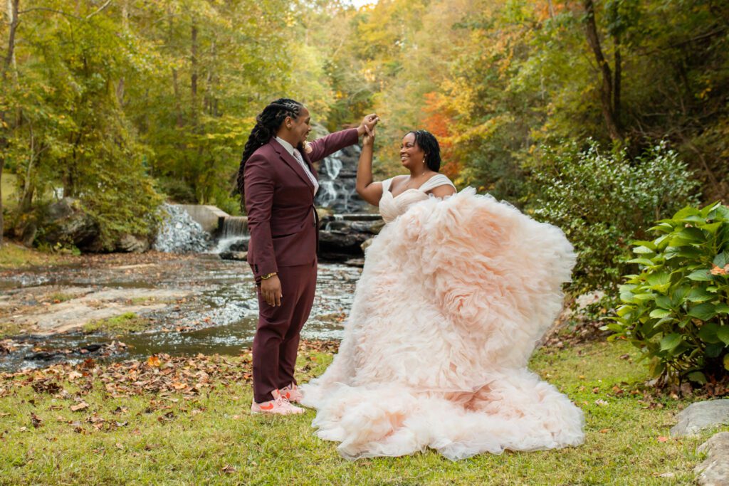 Wedding venue near Atlanta featuring a waterfall, bride in luxury designer wedding dress pose at an outdoor wedding ceremony during fall near Atlanta