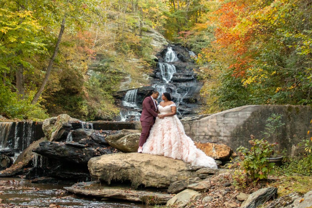 Wedding venue near Atlanta featuring a waterfall, bride in luxury designer wedding dress pose at an outdoor wedding ceremony during fall near Atlanta