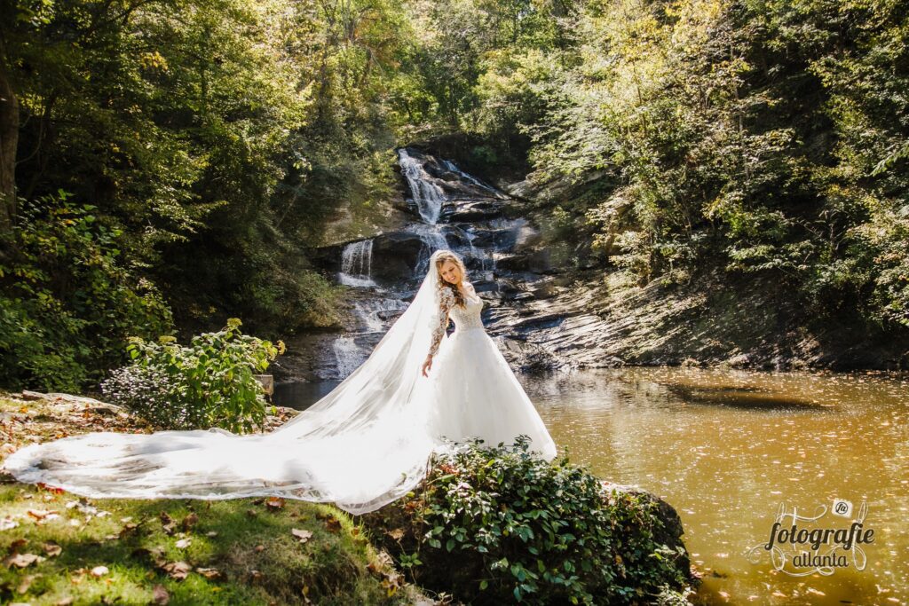 Our beautiful bride posing for wedding day photos by a waterfall wedding venue near Atlanta.