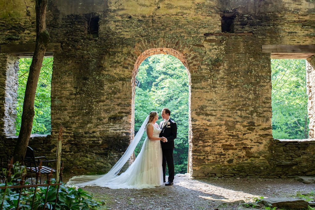 Bride and groom pose for wedding day photos with historic ruins at a wedding venue near Atlanta.