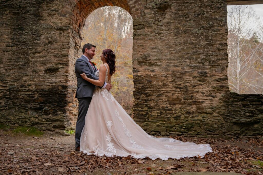 Bride and groom at Hightower Falls wedding venue surrounded by trees, historic stone ruins and the venue’s waterfall in Cedartown, Georgia.